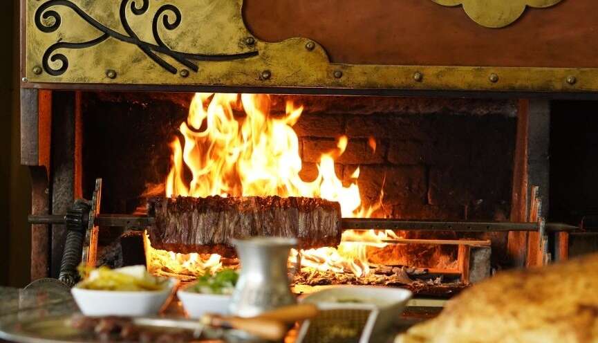 Ankara Bağlıca’da Yavuz Usta Oltu Cağ Kebabı restoranında, odun ateşinde pişirilen Oltu cağ kebabı ve yanında sunulan mezeler.